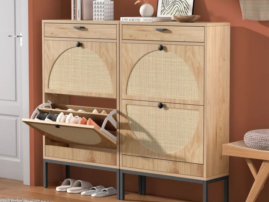 Two Bay Isle Home Cerina Boho Natural Rattan Shoe Storage Cabinet side by side with one cabinet open exposing pairs of shoes inside
