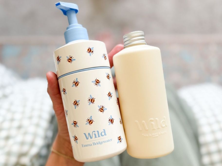 Hand holding a Wild Refillable Body Wash Pump Bottle and a refill
