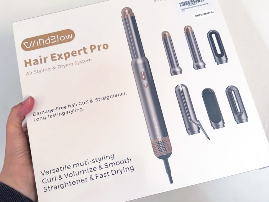 hand holding a white box to a hair dryer brush