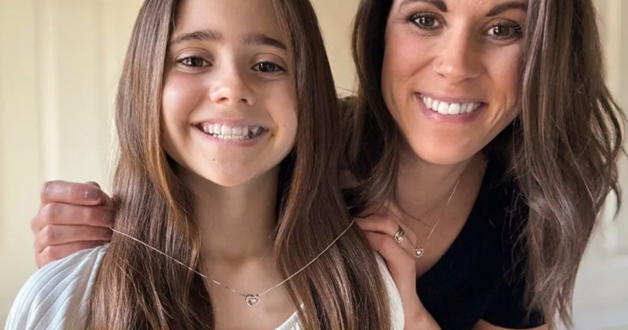 Woman putting a necklace on a child