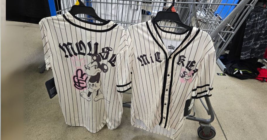 black and white striped Mickey Mouse Men's Graphic Baseball Jersey hanging on cart in store