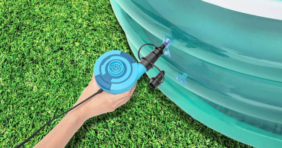 person using a bestway air pump to blow up a pool