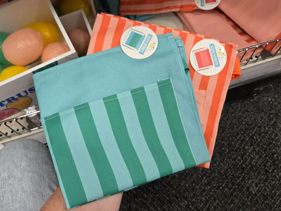 a green and blue striped and an orange striped Kid's Apron in store