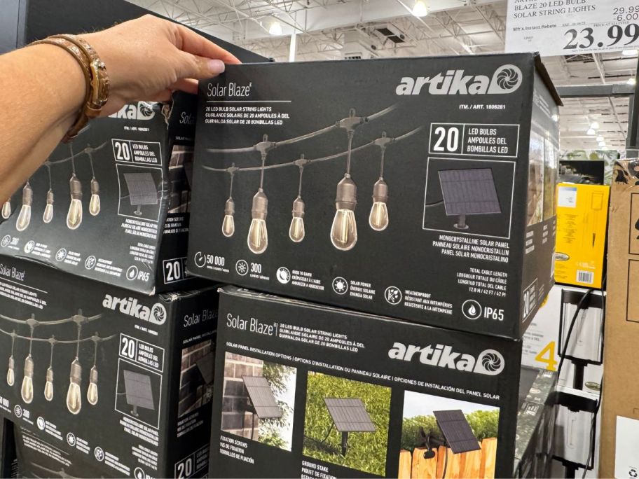 hand touching Artika LED Bulb String Lights 20-Count box in store