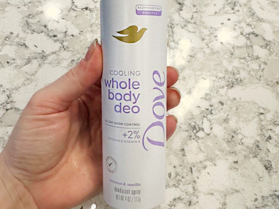hand holding dove deodorant bottle 