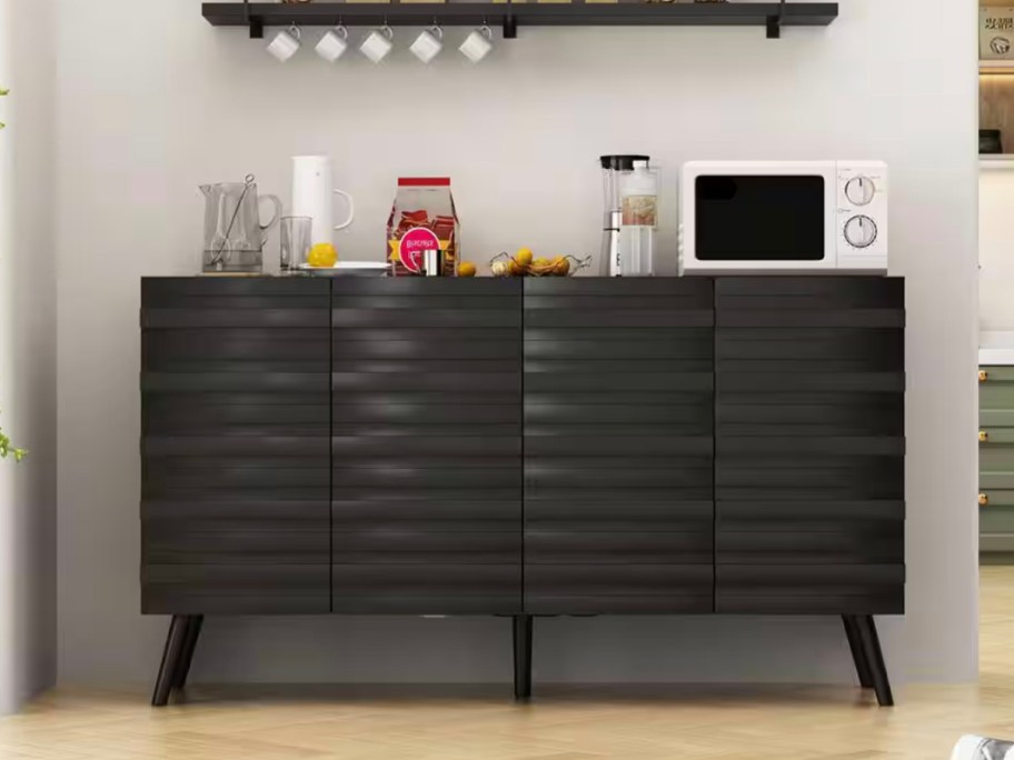 black sideboard with microwave and food on top 