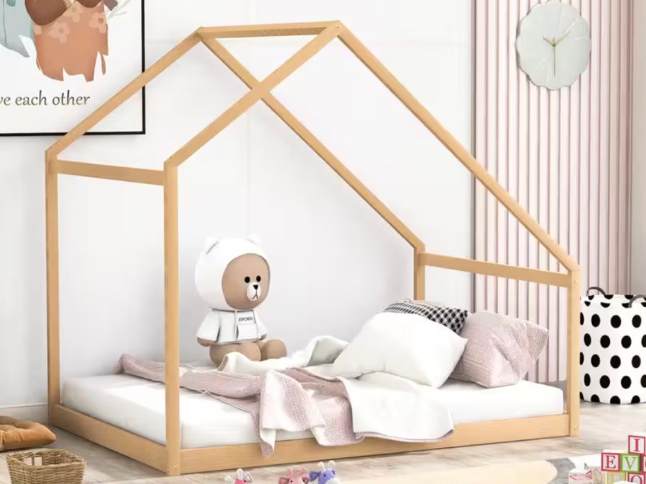 wood bed with blankets and teddy bear 