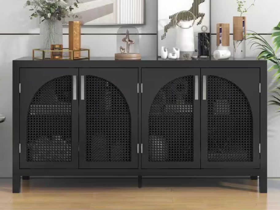 black sideboard with rattan doors with decor on top 
