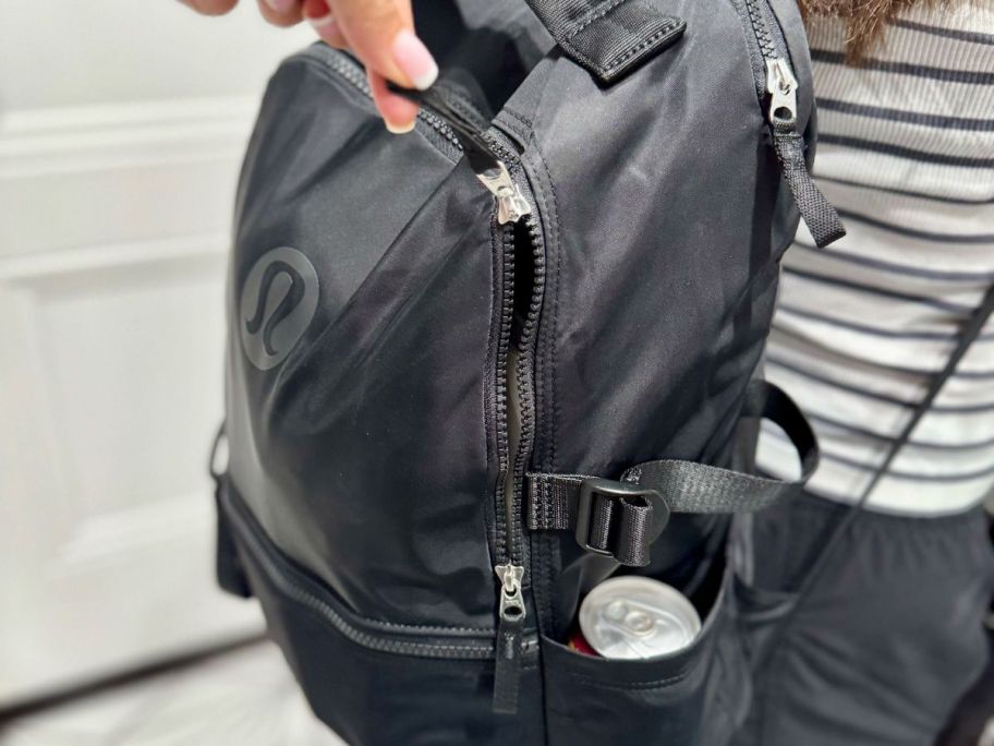 hand zippering a lululemon backpack