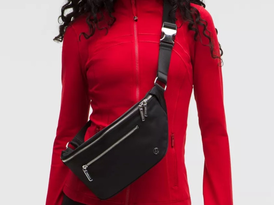 woman wearing a red top and a large black belt bag as a crossbody bag