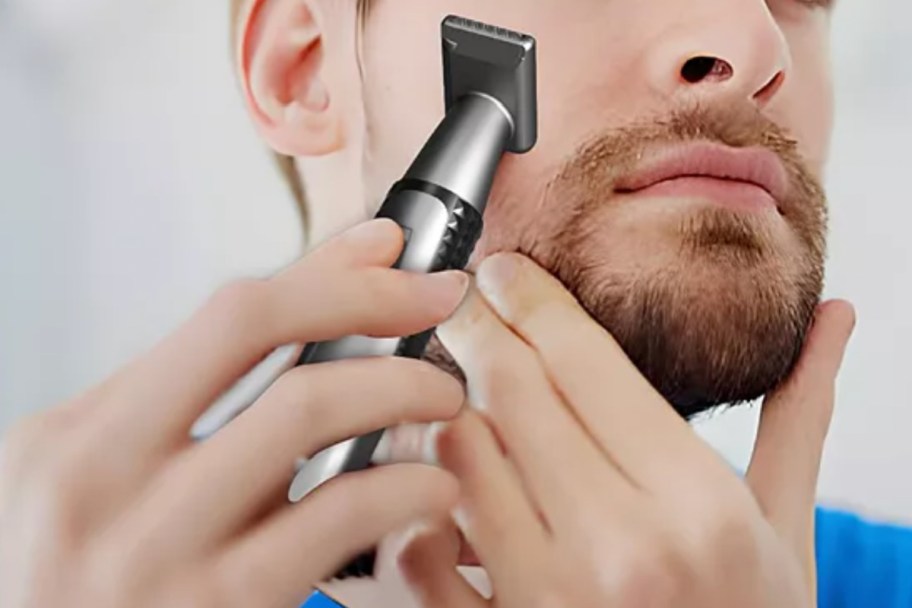 man holding trimmer up to face