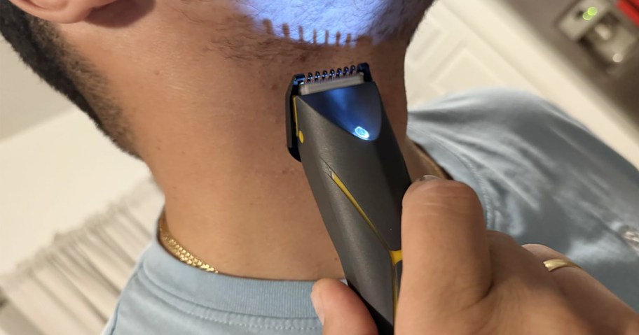man using a trimmer on his beard