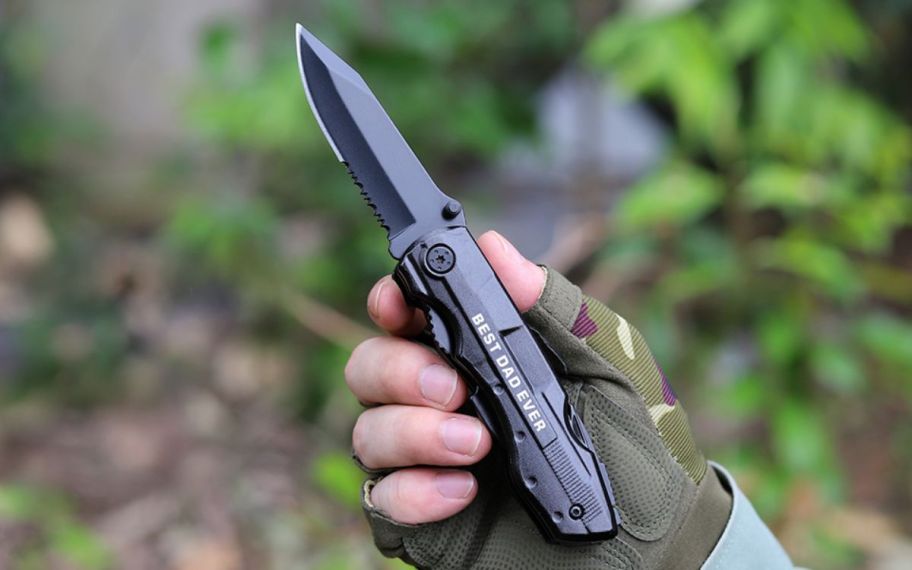 a mans hand holding a multitool open to pocket knife feature