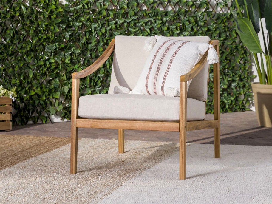 acacia chair with white cushion and blanket on top 