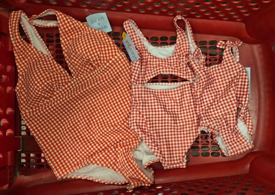 three red and white gingham check swimsuits in a red shopping cart