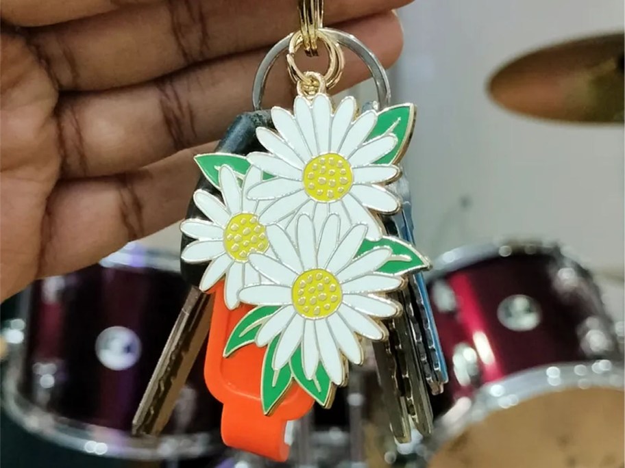 hand holding keys with daisy keychain 