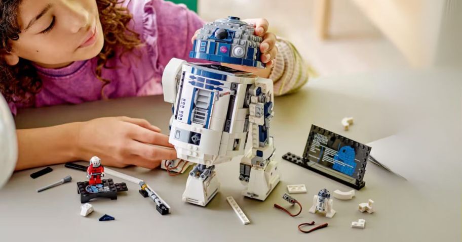 kid playing with star wars lego on table