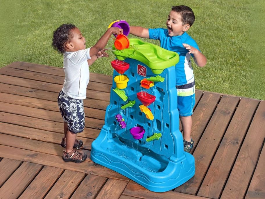 two kids playing with Step2 Waterfall Discovery Wall on deck