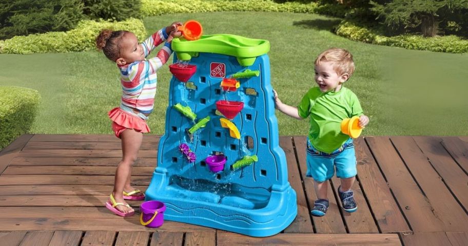 two kids playing with Step2 Waterfall Discovery Wall on deck