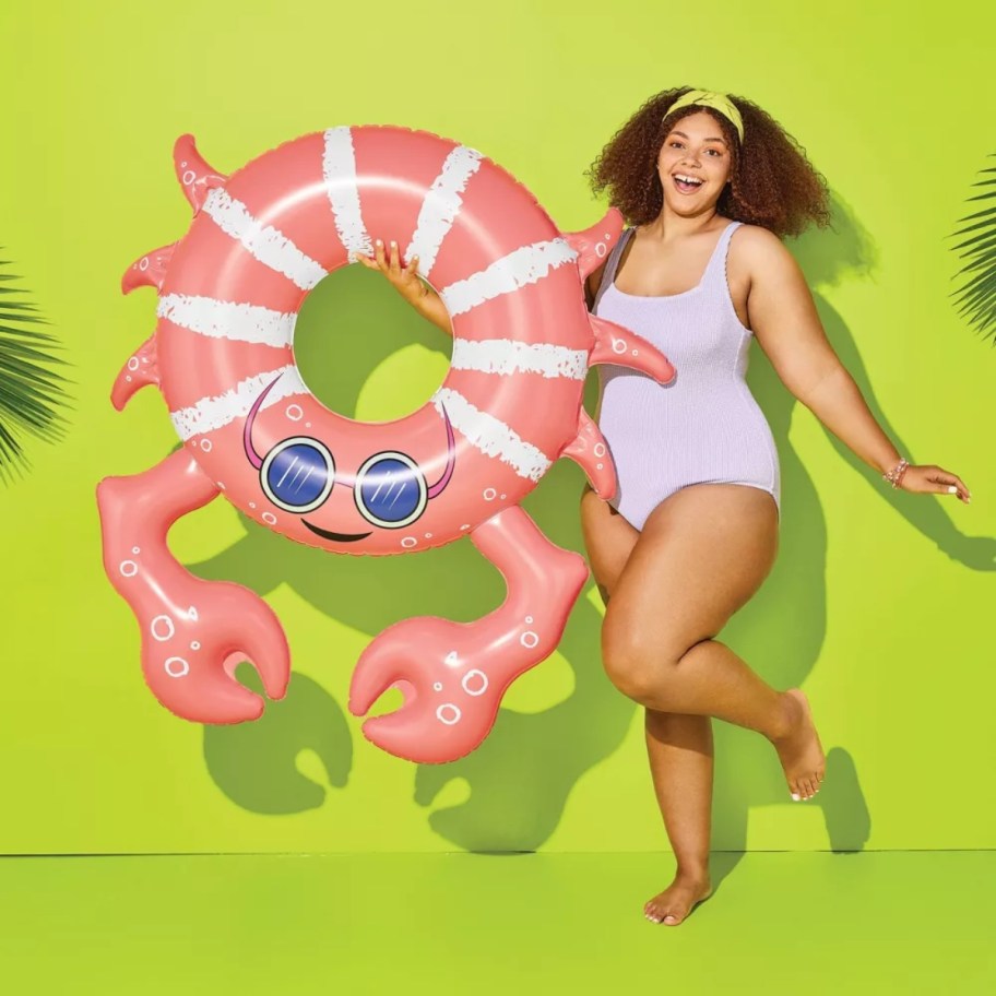 woman in a swimsuit with a crab shaped pool float