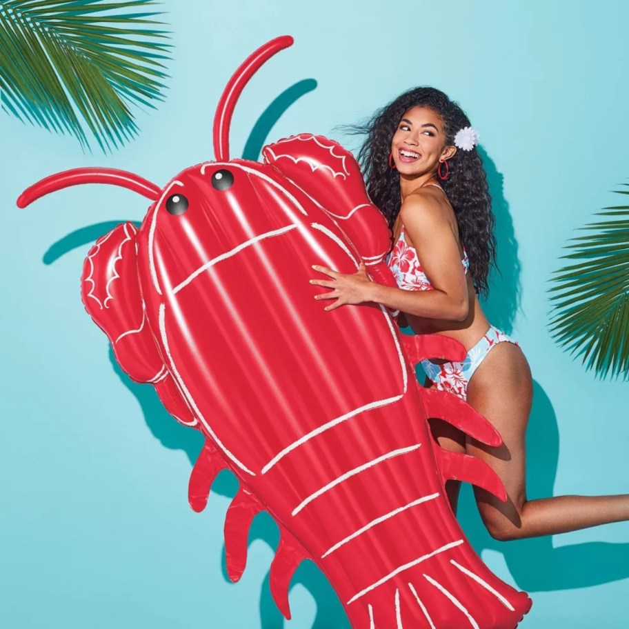 woman in a swimsuit with a lobster pool float