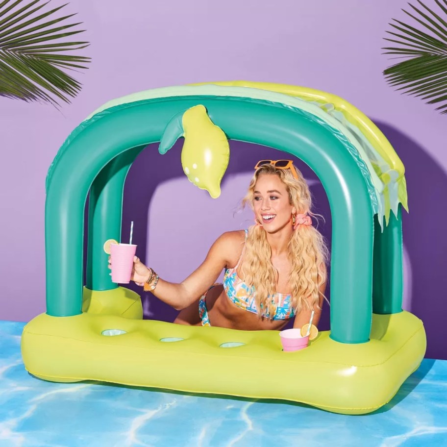 a woman behind an inflatable lemonade cabana