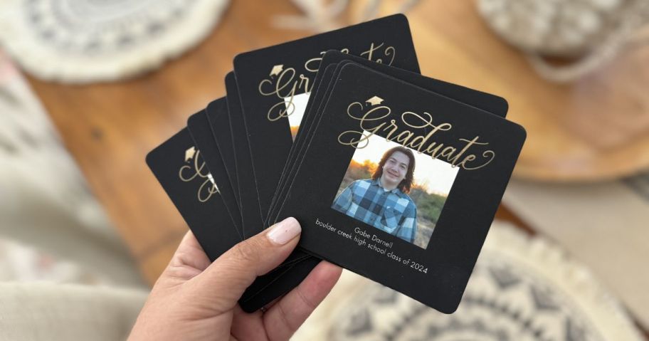 twelve black graduation Walgreens Photo Coasters in hand