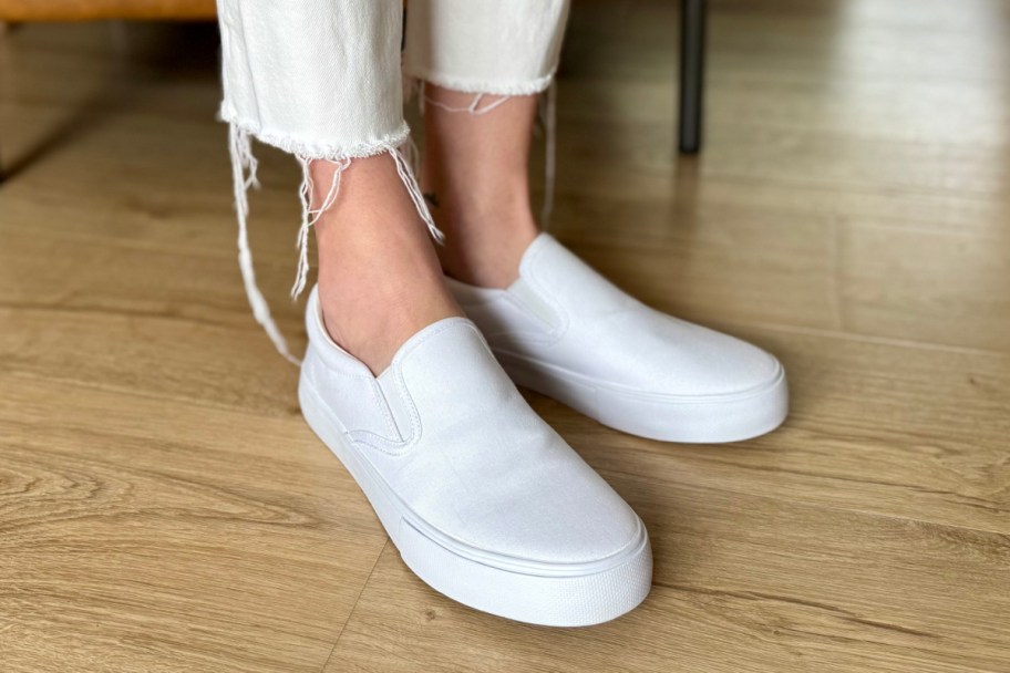 woman wearing white slip on sneakers