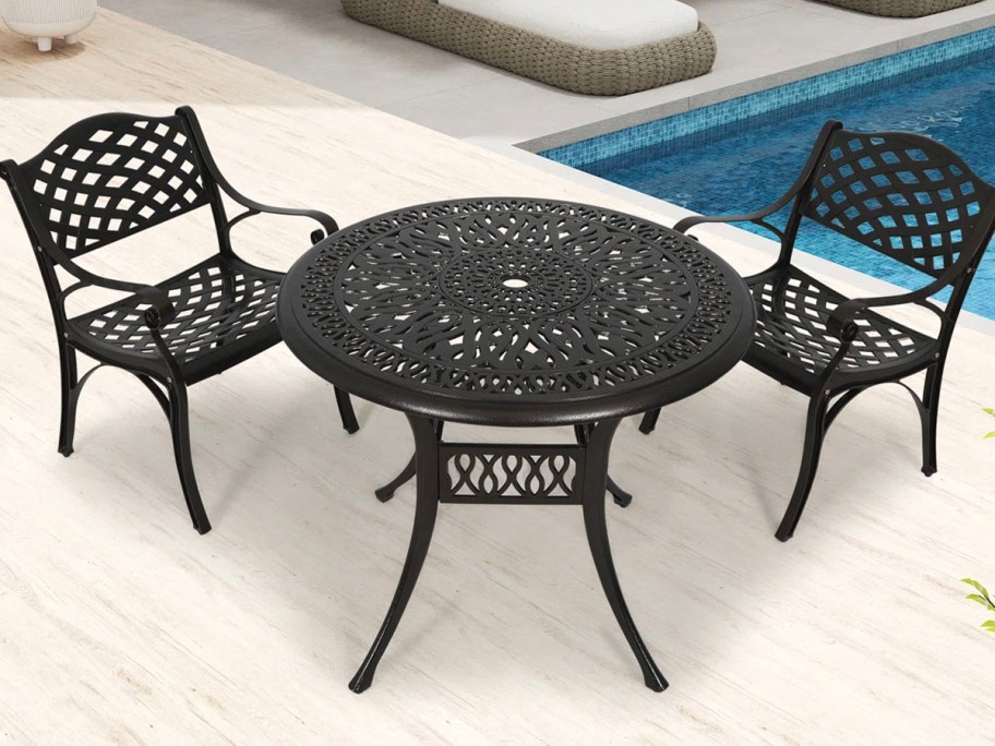 black table and chairs on patio with pool 