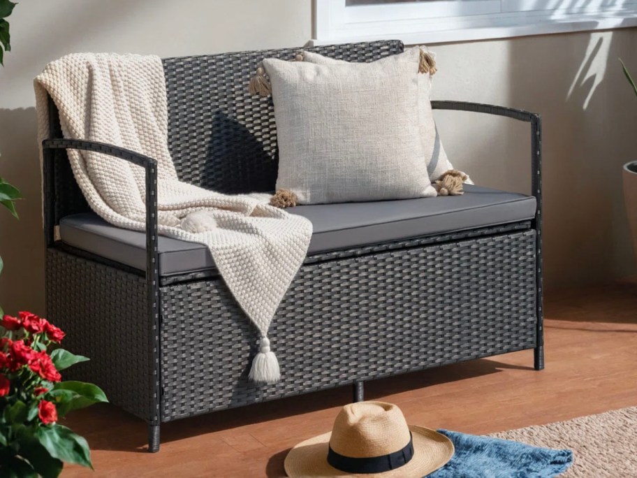 gray bench with white blanket and pillow 