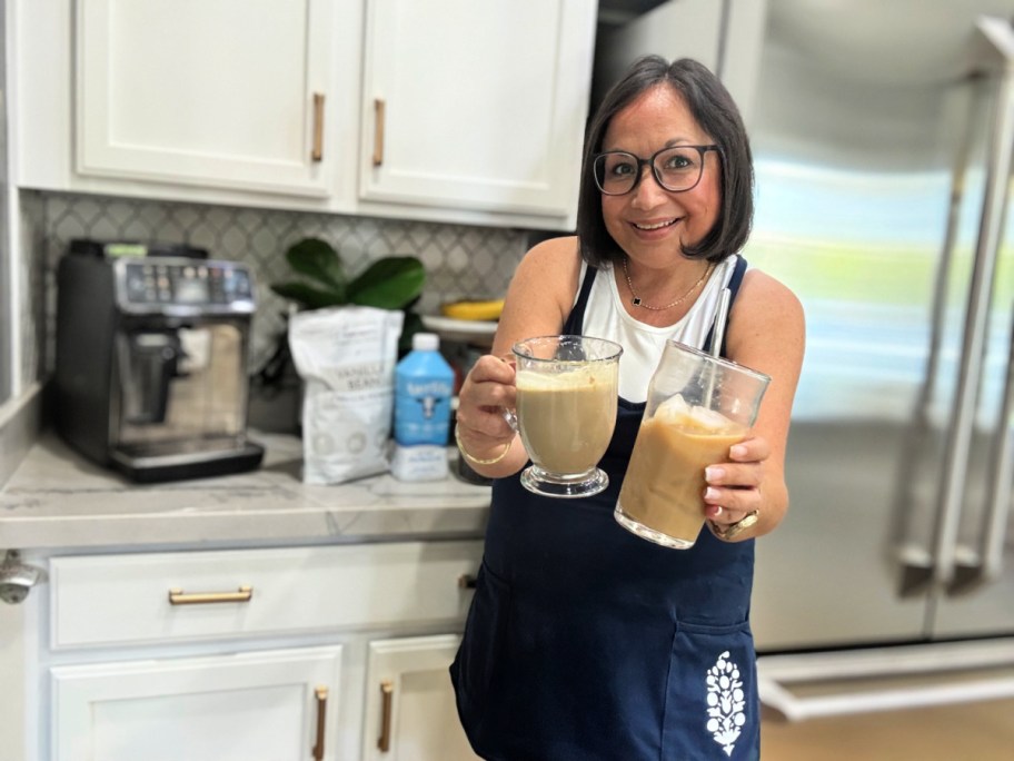 woman holding an iced protein coffee and hot proffee