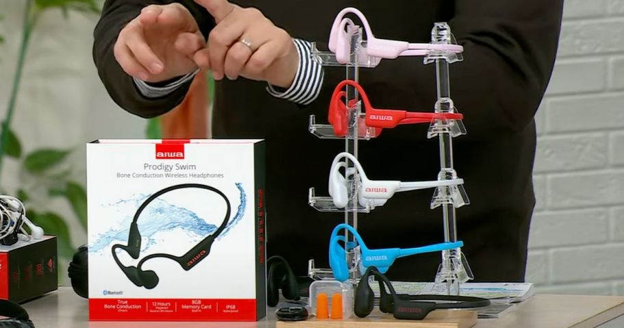 Aiwa Bone Conduction Headphones being demonstarted on HSN with all 5 color options displayed pn a stand