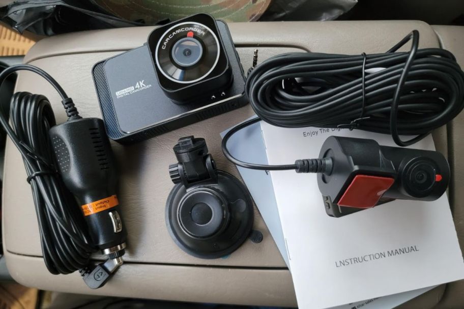 dashcam with all the items it comes with displayed inside of a car