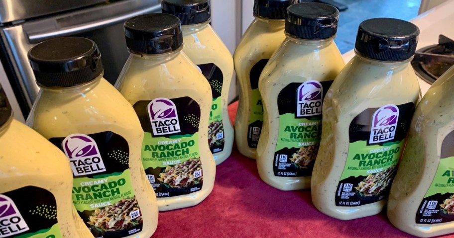 A lot of Taco Bell Avocado Ranch Sauce Bottles sitting on a counter in a kitchen