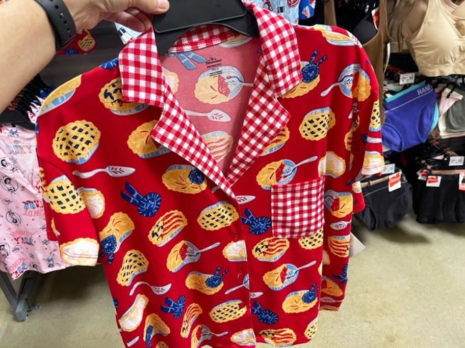 hand holding up a red pie-print pajamas set in store