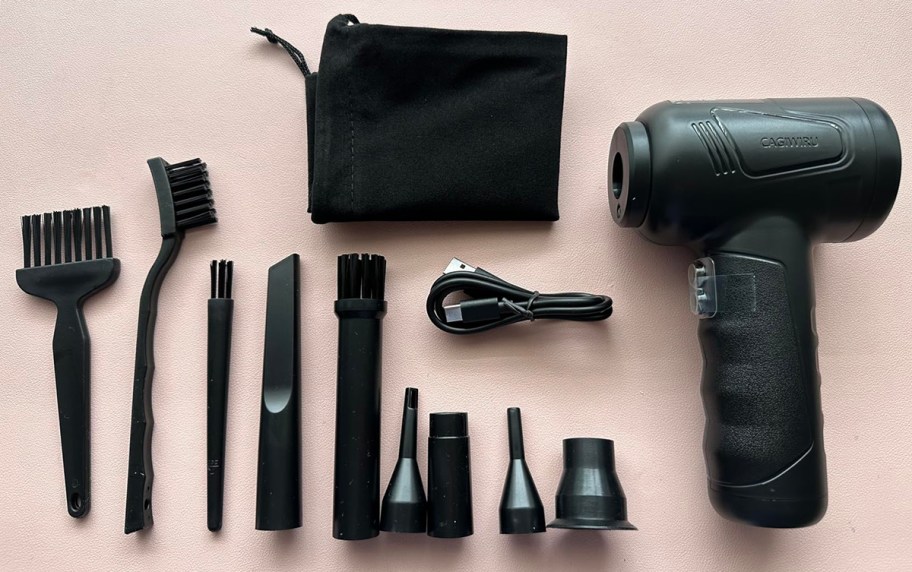 compressed air duster and accessories on a pink mat
