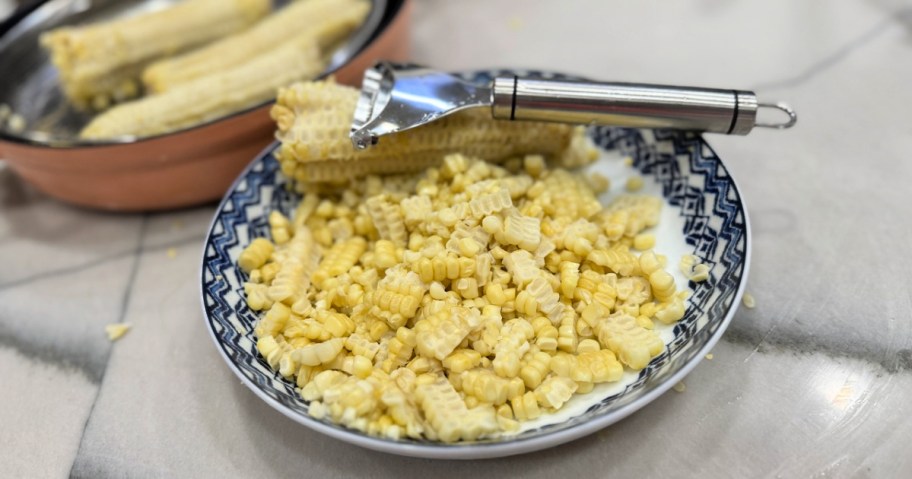 mooshion corn peeler on a bowl full of corn
