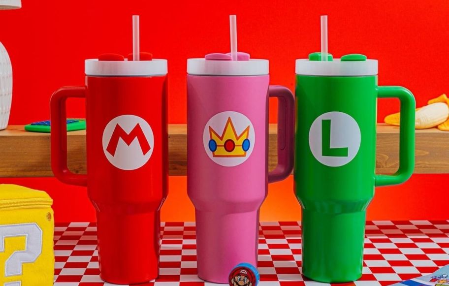 three nintendo tumblers one in red, one in green, and a pink one