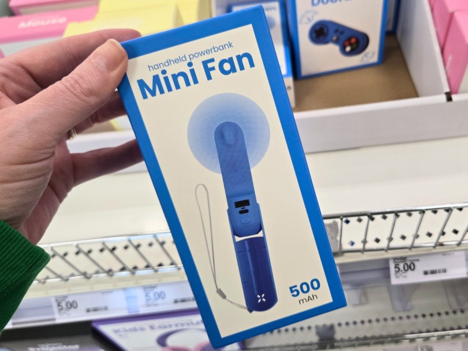 hand holding a box with a mini fan in it, more on a shelf behind it