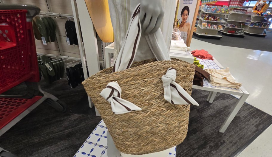 Target mannequin holding tote bag with scarf like detailing 