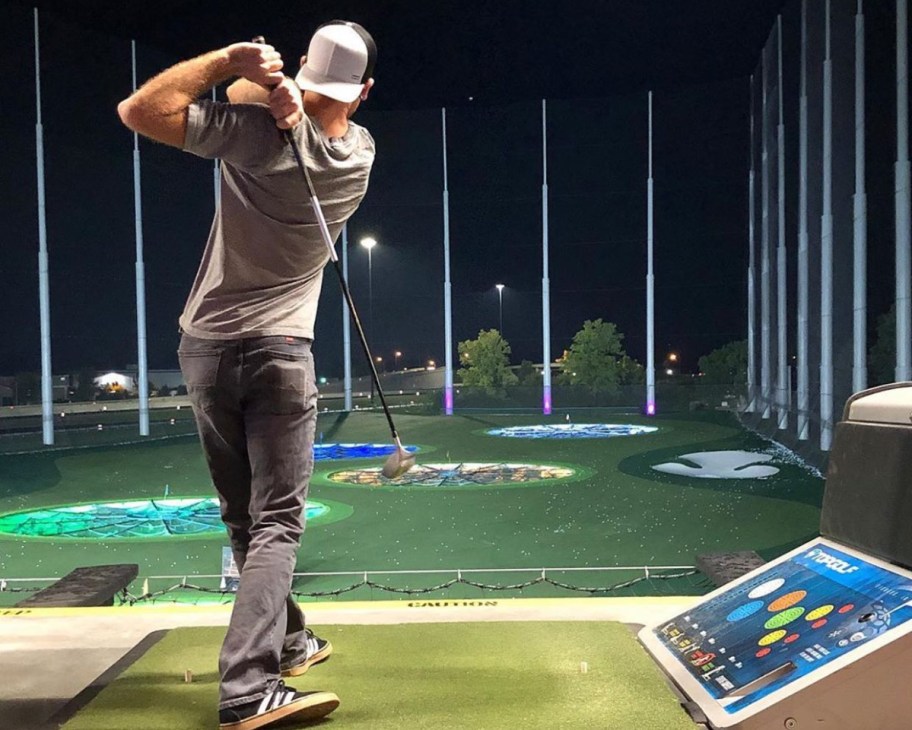 man swinging club at topgolf